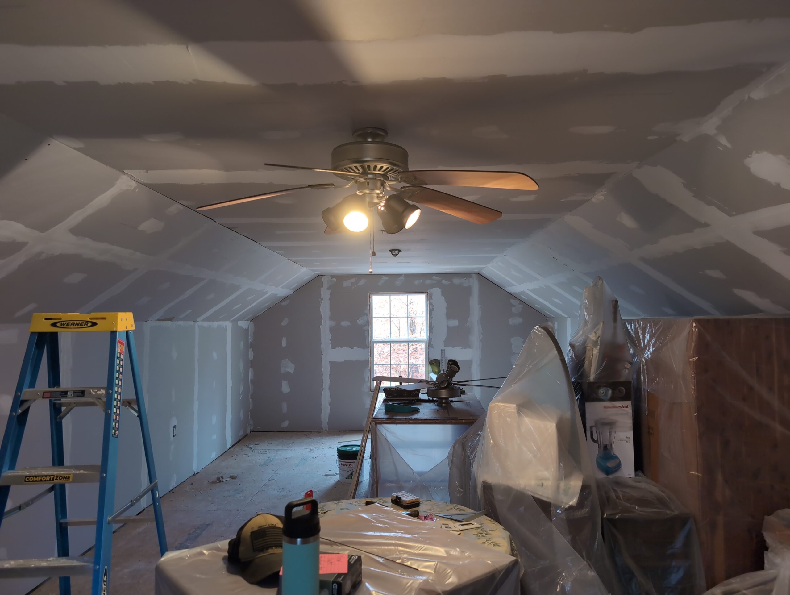 This image shows a barn loft that is in the process of being remodeled. The newly installed drywall is mostly finished.